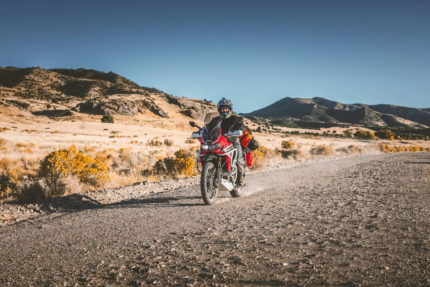 Rider on a dual-sport motorcycle on a gravel road