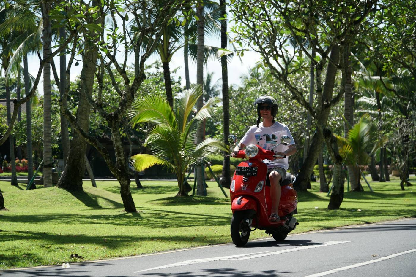 Rider on a red scooter on a park road